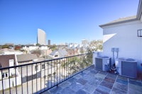 a balcony with two air conditioners and a view of the city