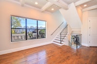 a living room with hardwood floors and a staircase